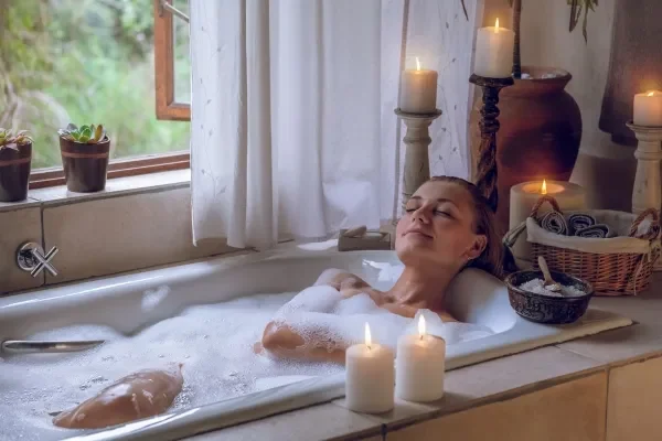 Woman relaxing in a spa with candles and relaxing beauty treatments
